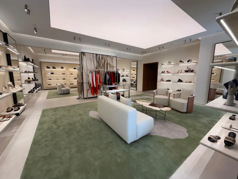 Interior de Ferragamo con tapetes verdes y mobiliario claro