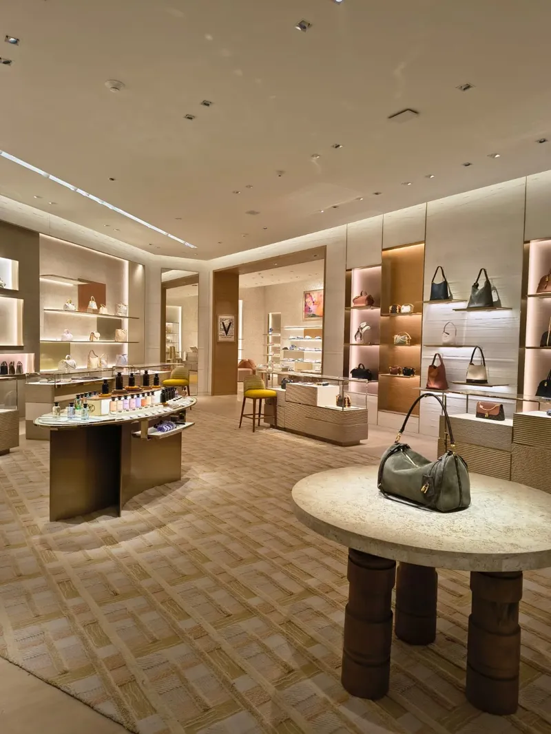 Área de bolsos y perfumería con mobiliario dorado