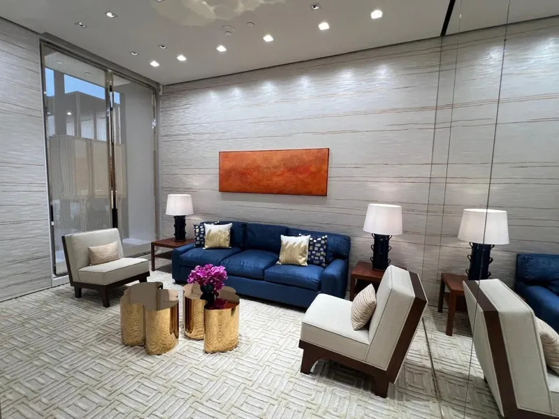 Private seating area with a blue sofa and light armchairs